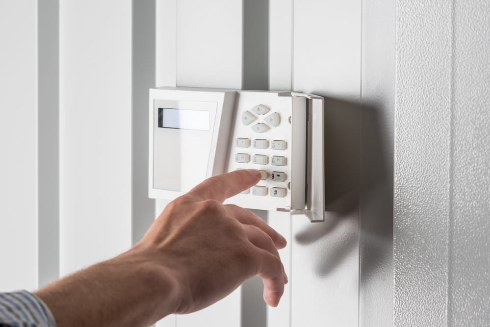 Person typing code on security keypad.