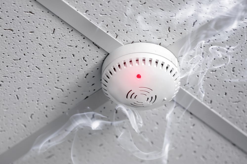Smoke detector activated with red light and smoke.